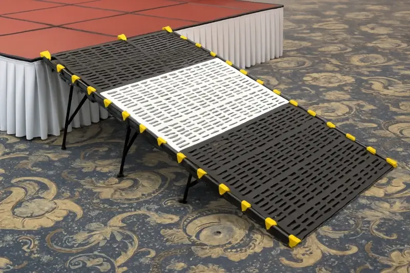 Black and white ramp with yellow grips for giving people with disabilities access to a stage or platform, equipped with support legs and an anti-slip surface for events and halls