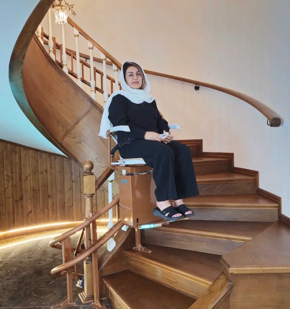 Curved stairlift on spiral staircase, senior seated, handheld remote