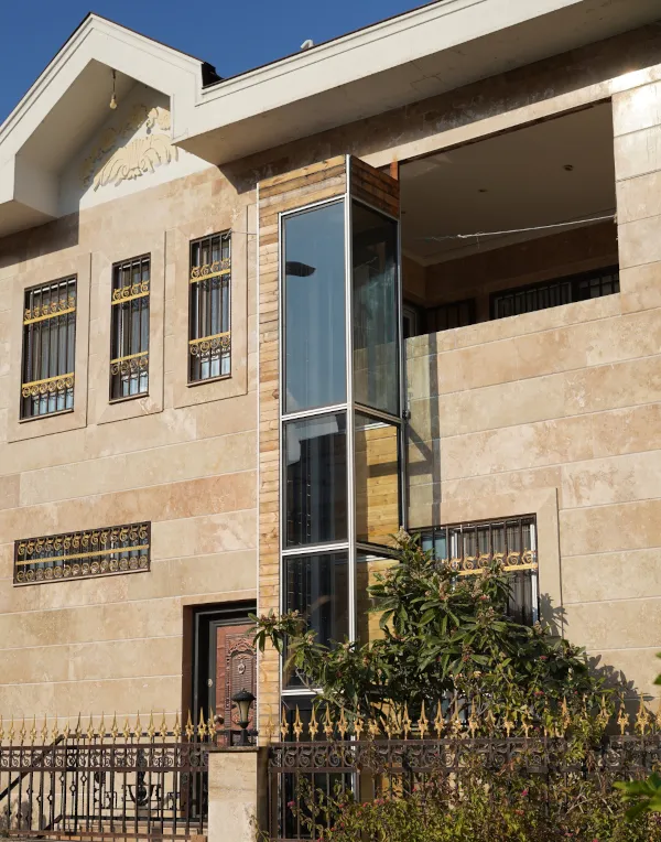 Glass home lift on exterior of a modern two-story house